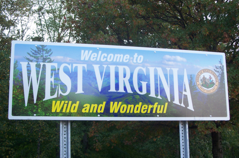 a "Welcome to West Virginia: Wild and Wonderful" road sign is seen surrounded by trees. BetRivers Sportsbook WV Launches, is 9th Sportsbook in State